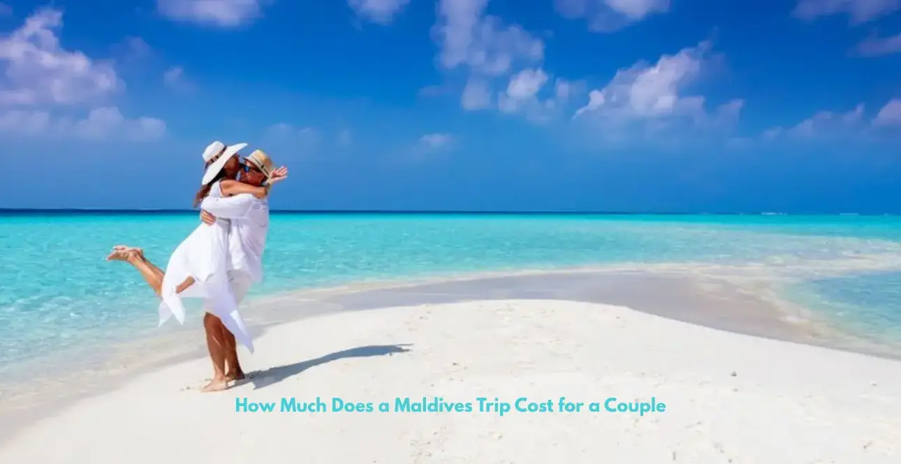 A couple embracing and laughing on a pristine white sandbar surrounded by bright turquoise ocean under a clear blue sky.