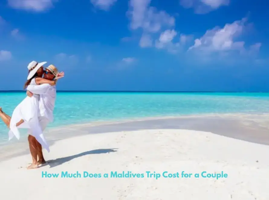 A couple embracing and laughing on a pristine white sandbar surrounded by bright turquoise ocean under a clear blue sky.