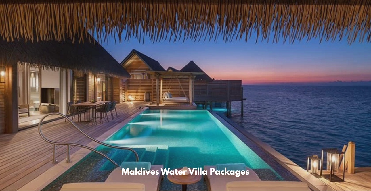 Luxury overwater villa at dusk featuring a private illuminated infinity pool, wooden deck, lounge chairs, and panoramic ocean views.